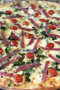 Pizza with red onions and tomatoes